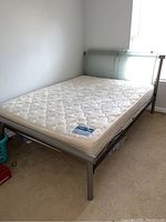 Full view of the metal bed frame with mattress showing overall condition and design.