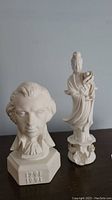 Full view of the Mozart bust and Asian lady figurine displayed side-by-side on a flat surface.