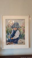 Framed original pastel artwork signed by Wanda Carter, showing a young child in a blue hat with floral background.