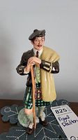 Front view of Royal Doulton figurine 'The Laird' showing the figure's face, traditional Scottish kilt, and walking stick.