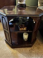 Octagonal side table with glass top and shelves showing decorative items