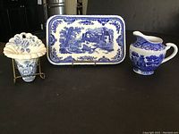 Photo showing all three pieces: tray, wall pocket and creamer, arranged together against a wooden backdrop.
