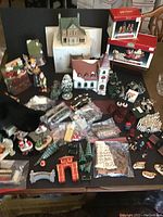Entire lot displayed on table with various miniature houses, trees, figurines, and accessories including visible light cords and boxes.