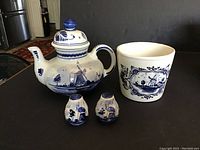 Full view of the teapot, planter, salt and pepper shakers displayed on a table showing their shape and painted details