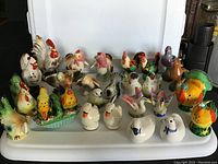 Full set of 27 vintage bird-shaped salt and pepper shakers displayed on white tray, featuring colorful chickens, ducks, pigeons, and turkeys. Visible paint loss and minor damage on some pieces.