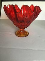 Front and top profile view of a medium Viking amberina pedal bowl with ruffled edges and a gradient amber to red color.