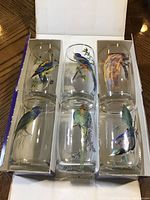 Photo showing three pairs of Ideal tumblers in original packaging with exotic bird illustrations on each glass.