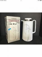 Photo of the Corning Thermique beverage server and its original box showing the front side with flower design and packaging.