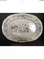 Front side of the vintage oval platter showing detailed Delia floral pattern in blue, pink, yellow and red on a cream background.