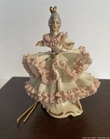 Single photo of the front view of the porcelain ballerina figurine showing detailed lace dress and gold hairpiece.