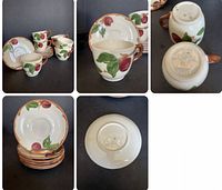 Full set of six apple pattern coffee cups and saucers plus the seventh mug without saucer arranged on dark surface, showing design and condition.