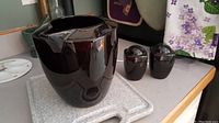 Black ceramic pitcher and matching salt and pepper shakers on countertop