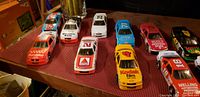 Photo showing 11 Nascar diecast cars on display with various race numbers and sponsorships.