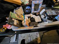 Various stationery and office items in bins including picture frames, paper, pens, Rolodex, Rubik's Cube, and electronic accessories