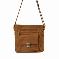 Tan leather crossbody bag shown hanging, displaying front with zipper pocket and flap pocket with silver clasp.