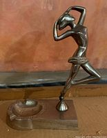 Overall perspective of metal Art Deco female dancer ashtray on rectangular base showing figure and ashtray