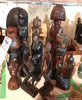 Group photo of 11 carved wood sculptures and figurines showing varying heights approximately 8-14 inches