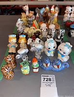 Overall lot display showing diverse vintage porcelain and ceramic salt and pepper shakers featuring animals and cartoonish characters in various colors and sizes.