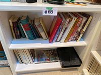 Shelf with two rows of books, assorted titles and sizes visible
