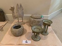 Photo showing entire lot with camel sculpture, two pottery jars, and two candle holders.
