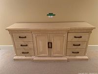 Front view of entire dresser showing nine drawers and central cabinet doors with metal handles.