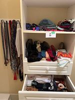 Shelves and drawers containing purses, belts, gloves, socks, and other accessories