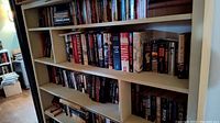 Wide view bookshelf with mostly hardcover Stephen King novels, various sizes and editions.