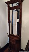 Full view of tall carved wood hall mirror showing rectangular mirror, twisted columns and carved base.