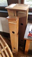 Two wooden Aeolian harps side by side, view of full bodies and tuning pegs