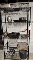 Front view of one metal wire shelving unit containing kitchenware, highlighting height and shelf spacing