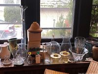 Wide view of all items arranged on a windowsill including glassware, pottery, and baskets