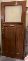 Full view of vintage 1920s oak front door with single pane glass and three vertical panels