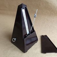 Front angle showing pyramid shape, pendulum bar with adjustable weight, and removed front cover.