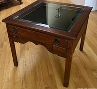 Overall view of cherry wood end table showing inset beveled glass top and structure.