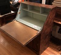 Front and side view of writing desk with fold-down table open showing blue-green painted interior shelves and sponge-painted exterior.