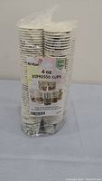 Two packs of 100 paper espresso cups each, wrapped in clear plastic, with Hot Kopi brand label and 4 oz capacity stated.