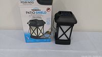 Front view of the Thermacell Patio Shield outdoor mosquito repellent lantern with box.