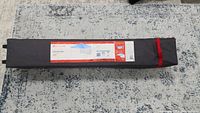 Tent sun shelter in a gray carry bag with red zipper.