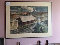 Framed watercolor painting showing overall railroad yard scene with smoke from locomotive.