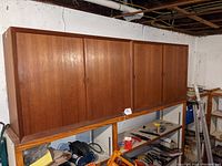 Both teak storage units side by side on metal shelving
