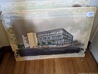 Photo of the first watercolor architectural rendering showing a rectangular multi-story building.