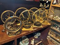 Group view of eight brass-tone electric clocks on shelf