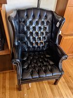 Front view showing tufted back and seat, rolled arms, nailhead trim