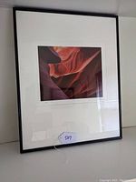 Front view of the framed photograph against a wall