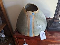 Front view of the large pottery vessel showing blue and green glazes with irregular rim.