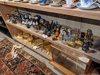 Full view of salt and pepper shakers collection spread across shelf, showing a wide variety of pairs and singles in several materials and shapes.