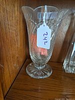 Clear large Waterford crystal vase showing scalloped rim and detailed cut seahorse pattern with diamond and starburst cuts, on a pedestal base.