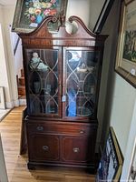 Full view of the mahogany china closet showing the entire piece with upper glass doors and lower cabinet.