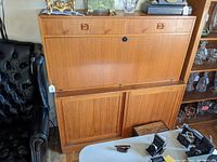 Closed front view of entire two-part teak desk with drop front and sliding doors below