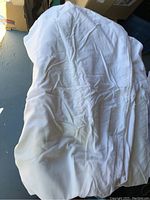 White queen size top sheet showing creases and folds laid flat